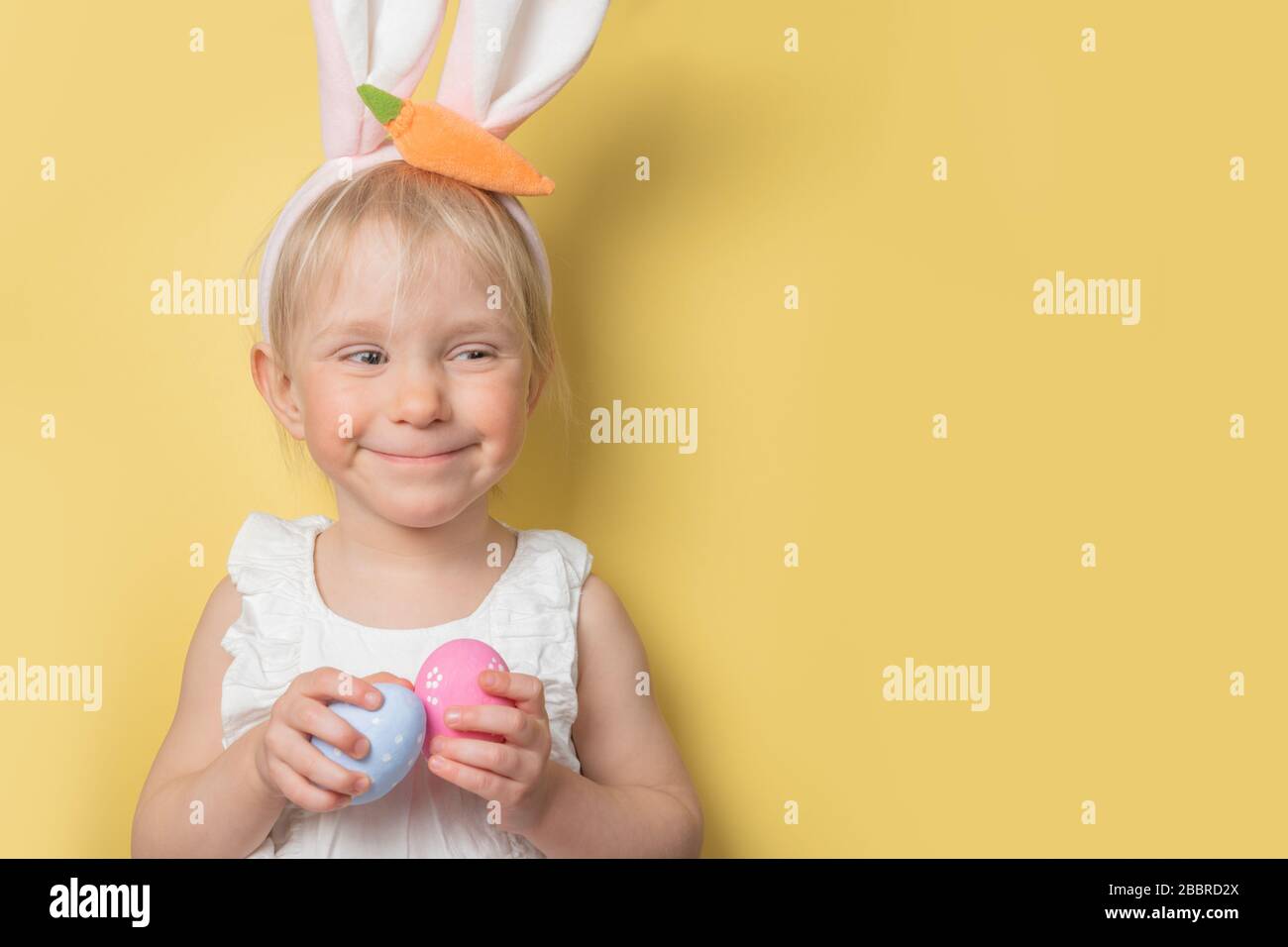 Easter concept child wearing easter bunny ears and holding eggs Stock