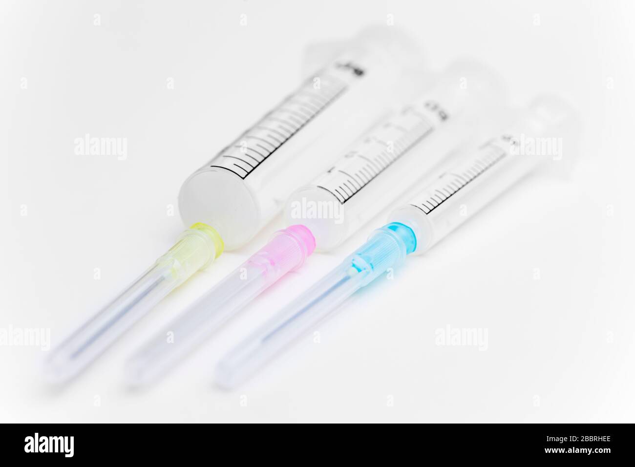 Three syringes in different sizes an colors on white background used as
