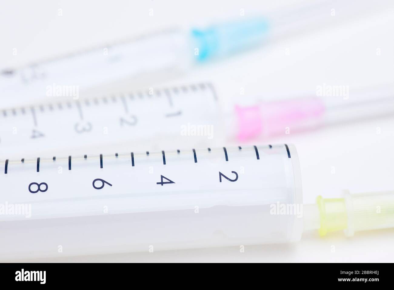 Three syringes in different sizes an colors on white background used as