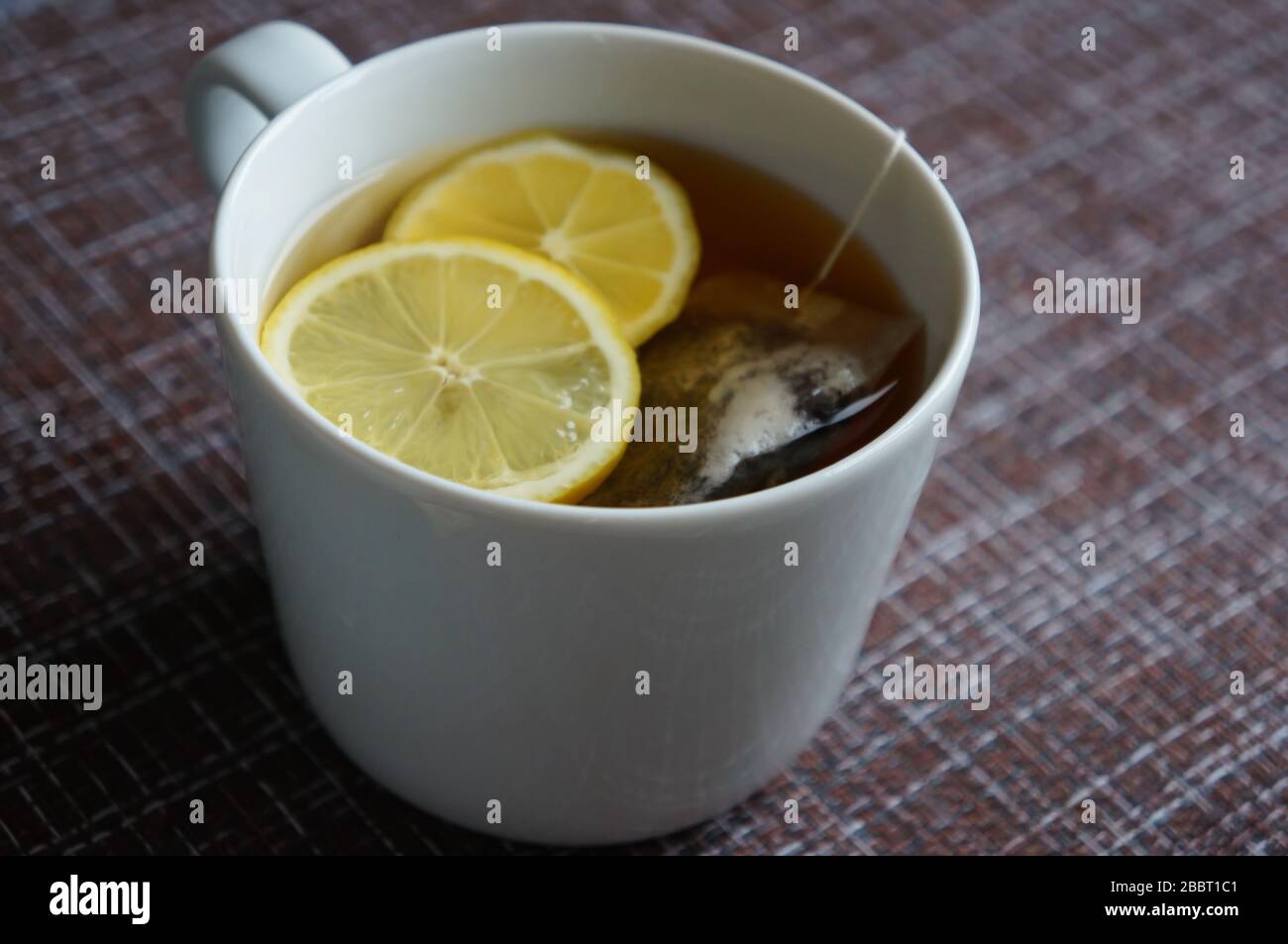 a cup of black strong tea with lemon and tea bag, against the virus and the common cold Stock Photo
