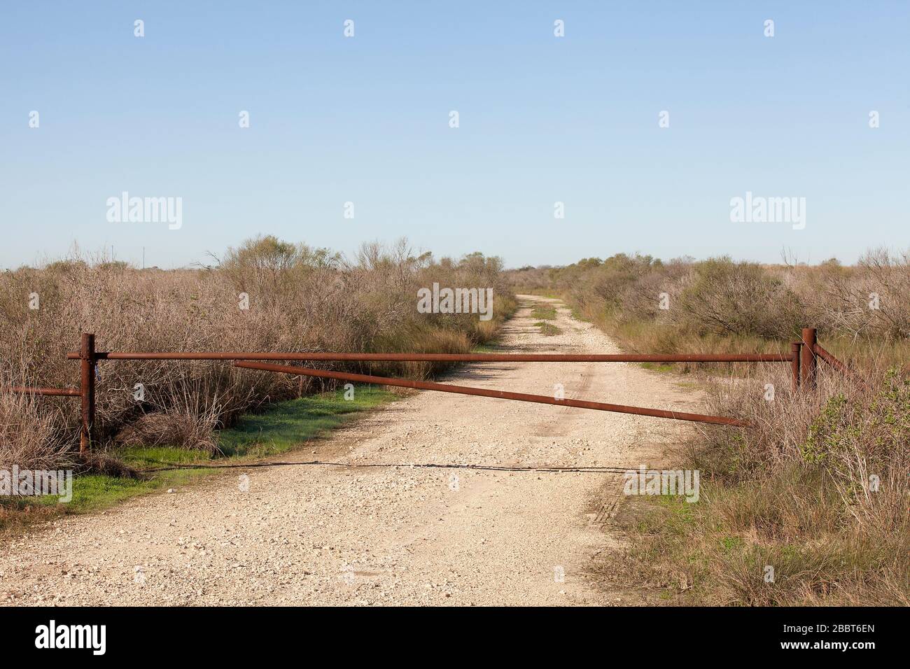 Gate at the entrance of a dirt road to an oil rigs field in Galveston ...