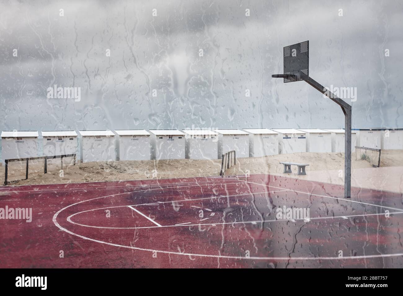 Beach basketball pitch seen through rainy window. of cafe Stock Photo