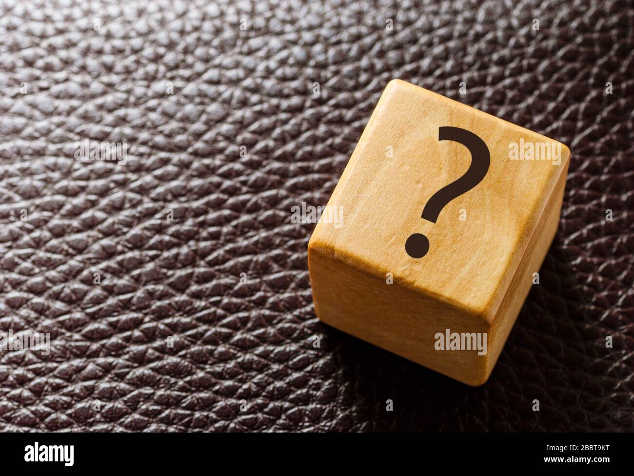 Wooden toy block with question mark on leather Stock Photo Alamy