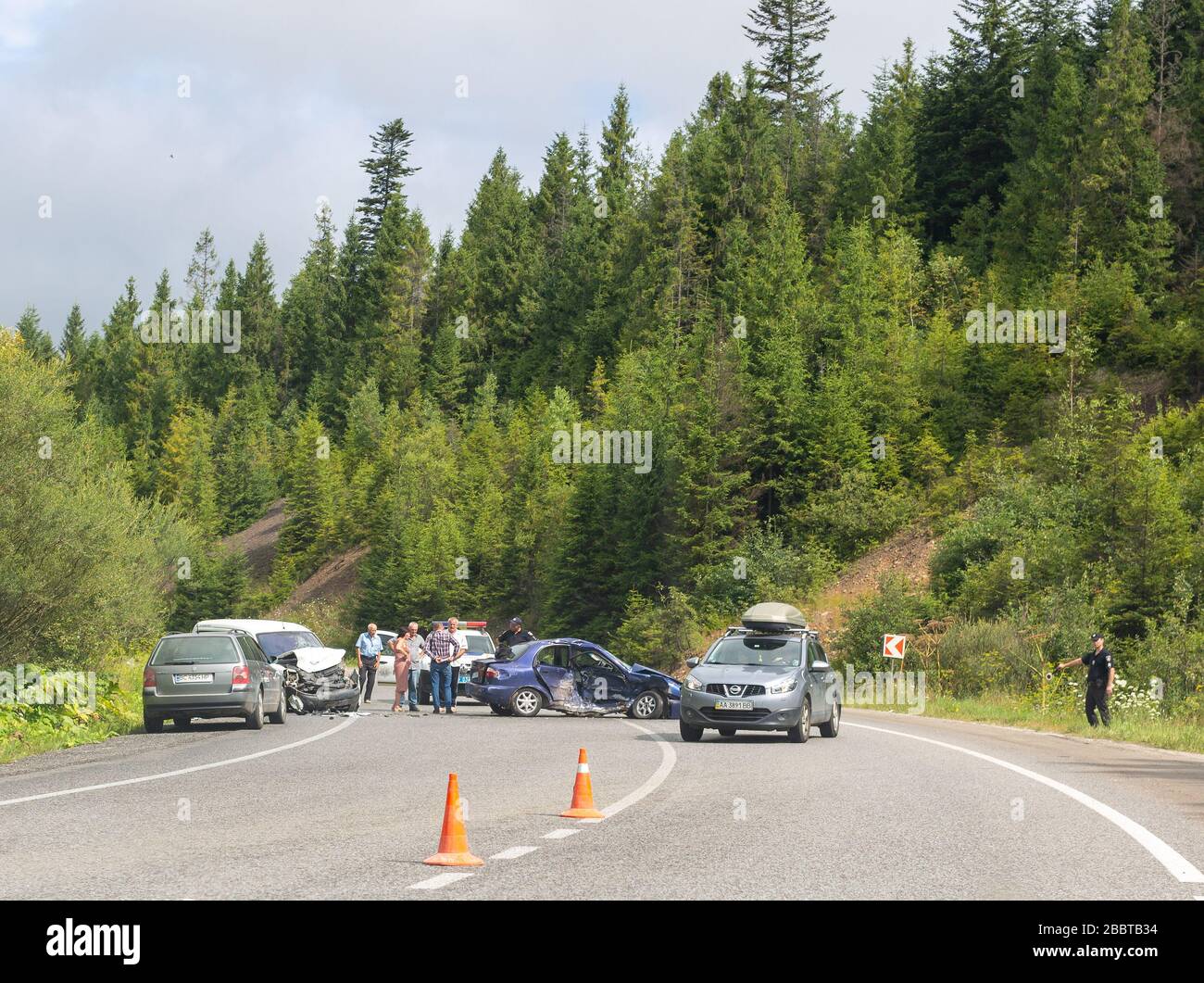 Svalyava, Ukraine. August 11, 2019: Fatal traffic accident. Real event. Two cars crashed on the road. Police officer interrogates participants and wit Stock Photo