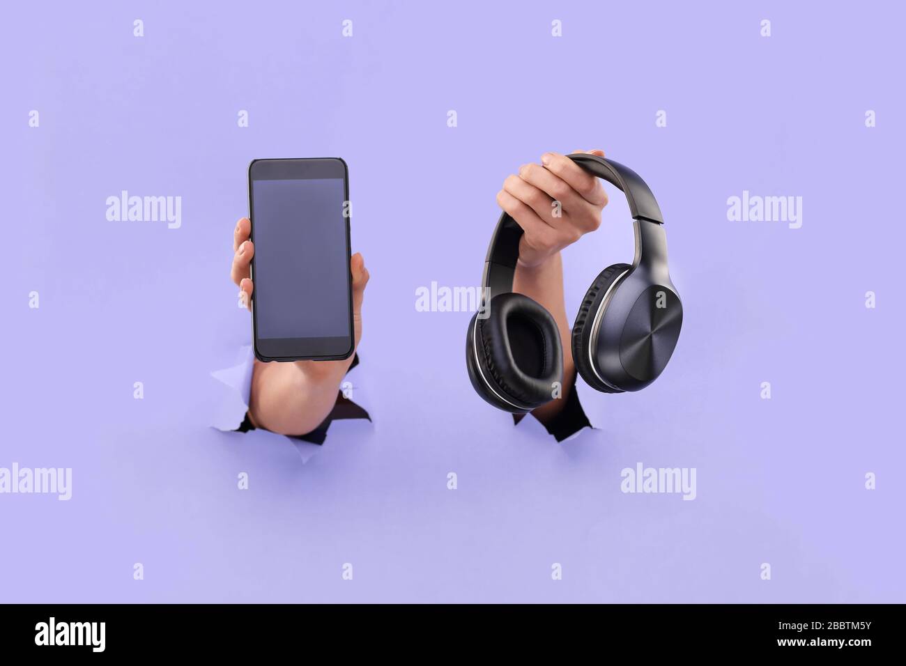 Smartphone and bluetooth headphones stick out from a Blue torn background.  Copy Space. Music Mobile App Concept Stock Photo - Alamy