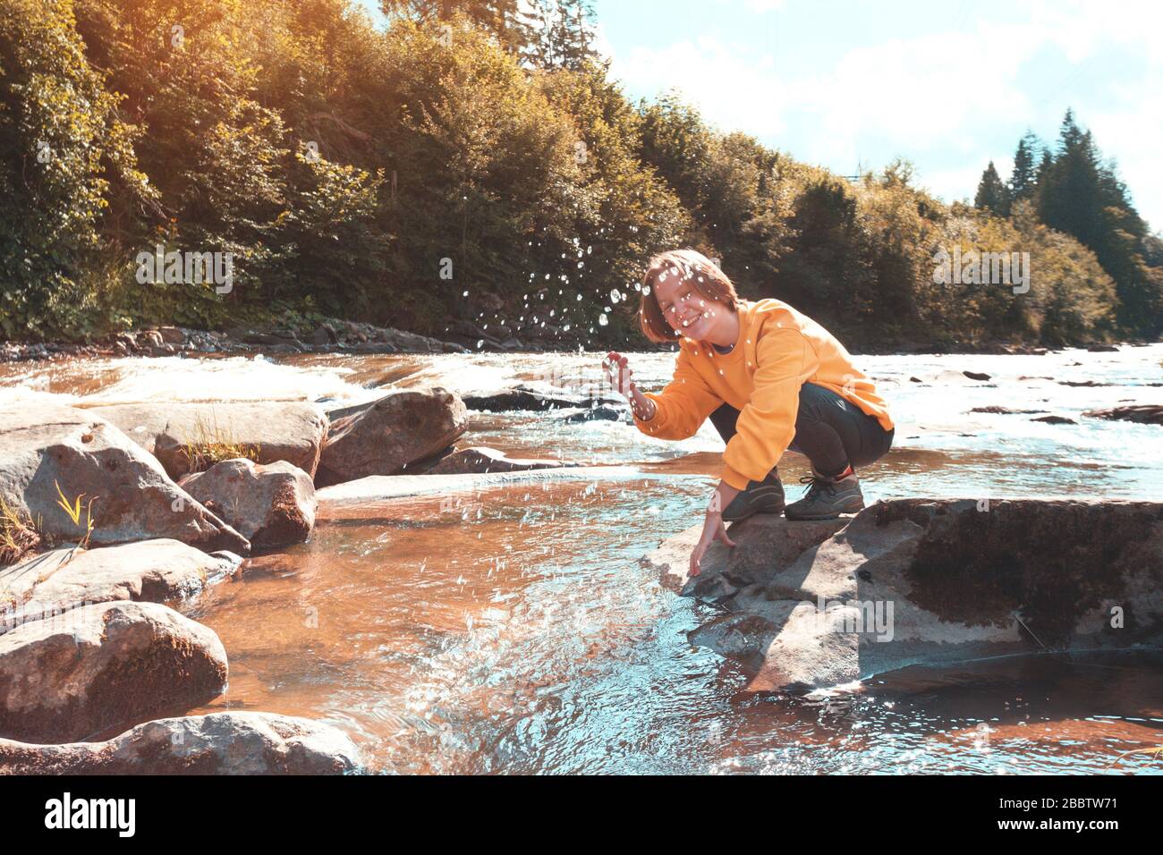 tourist girl sitting on the bank of a mountain river Stock Photo - Alamy