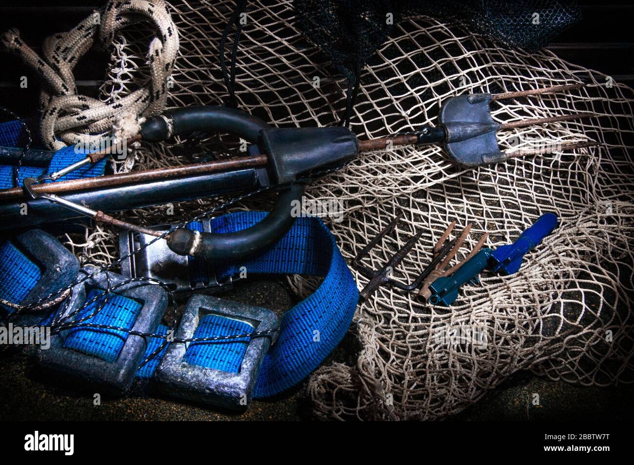 Details of scuba-diving and spear-fishing gear over a old fishing