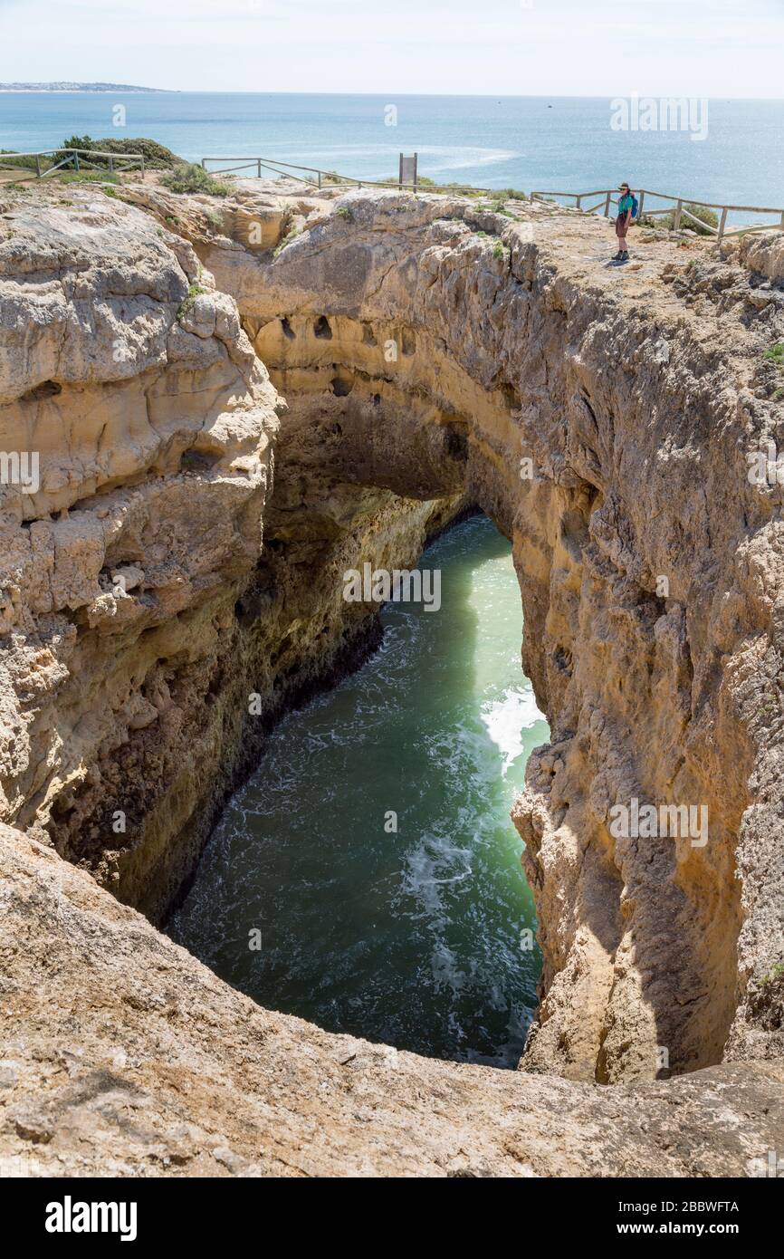 Sea arch and blowhole on the coast west of Alporchinhas, Algarve, Portugal Stock Photo