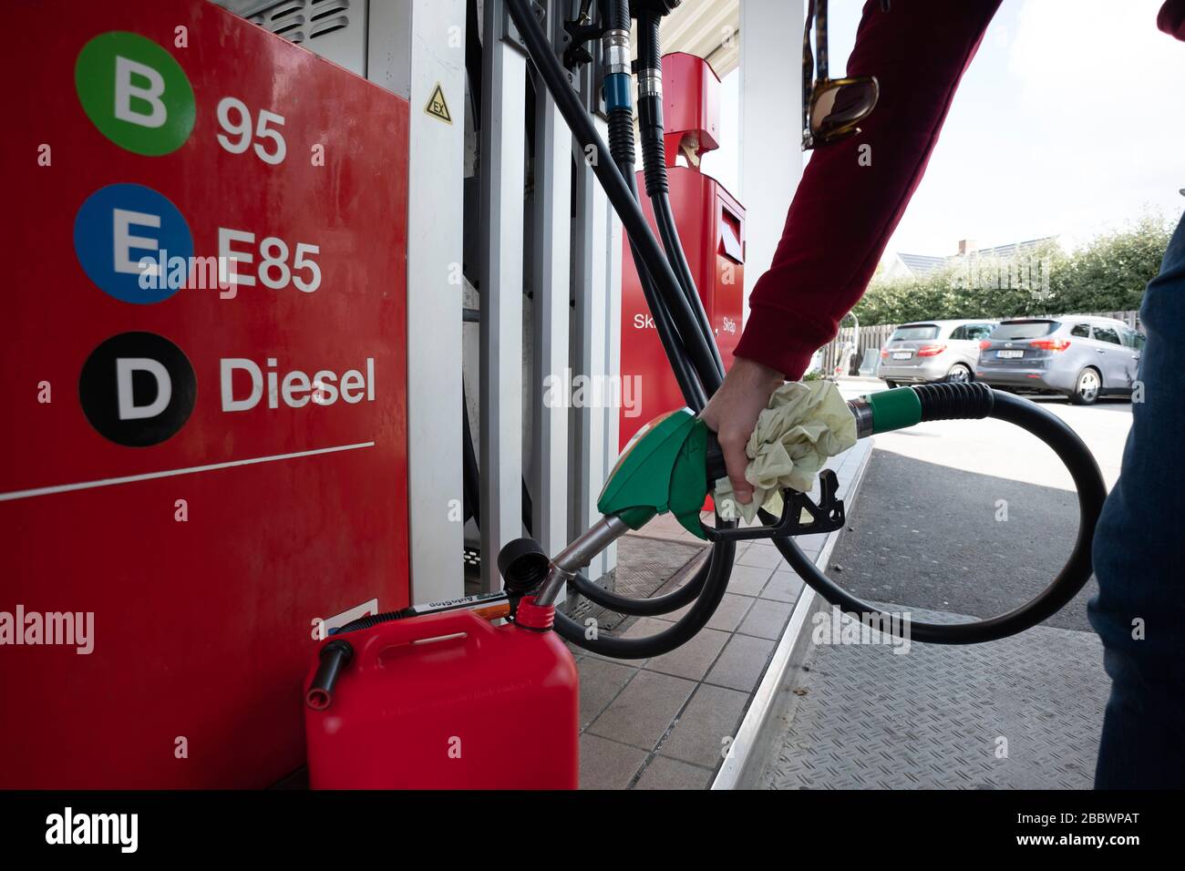 Person filling up a jerrycan fuel container at a petrol station Stock Photo