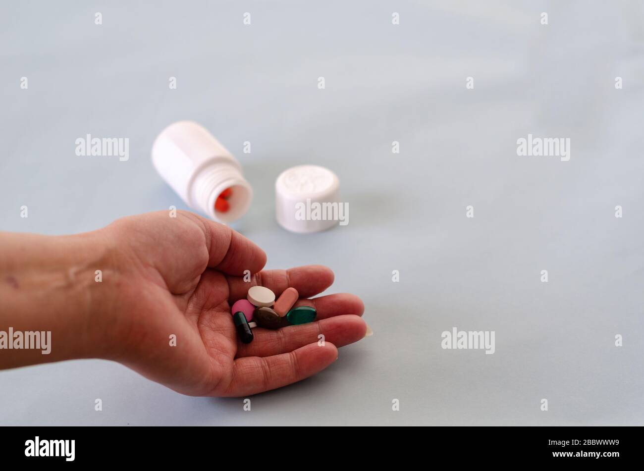 Assortment of medicinal pharmaceutical products, tablets, pills, capsules. Concept of healthcare and medicine. treatment of viruses. The woman is hold Stock Photo