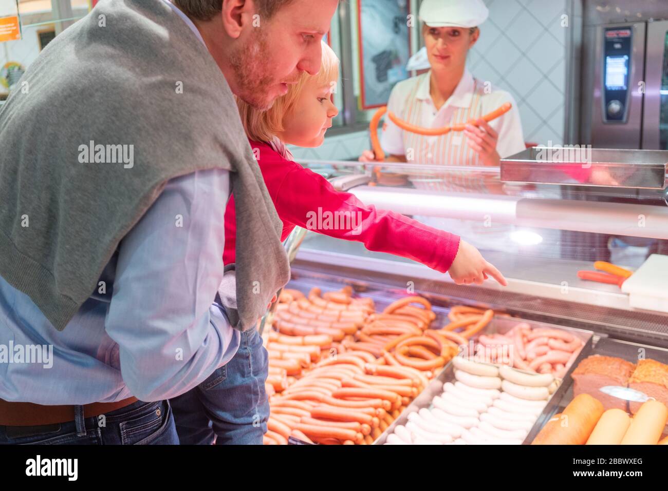 Family shopping for fresh meat in a supermarket Stock Photo