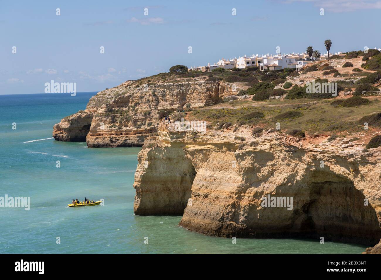 Sightseeing boat visiting sea caves on the coast west of Alporchinhas, Algarve, Portugal Stock Photo