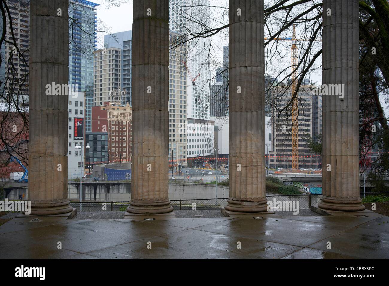 Pillars at Seattle's Plymouth Pillars Park with high-rise buildings in the background. Stock Photo