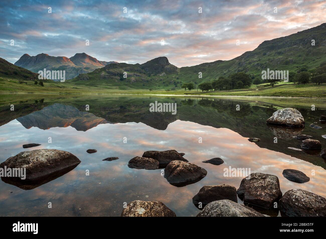 The Langdale Pikes reflected in the waters of Blea Tarn, Lake District National Park, Cumbria, England, UK Stock Photo