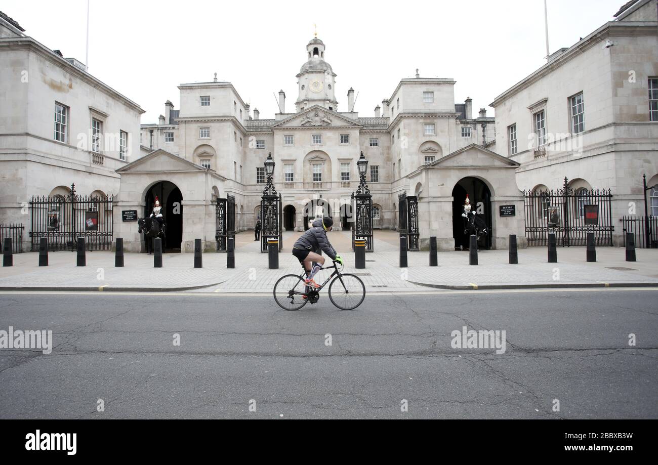 London, UK. 01st Apr, 2020. Day Nine of Lockdown in London. A lone cyclist goes past the Household Cavalry museum with no tourists around at all on Whitehall. The country is on lockdown due to the COVID-19 Coronavirus pandemic. People are not allowed to leave home except for minimal food shopping, medical treatment, exercise - once a day, and essential work. COVID-19 Coronavirus lockdown, London, UK, on April 1, 2020 Credit: Paul Marriott/Alamy Live News Stock Photo