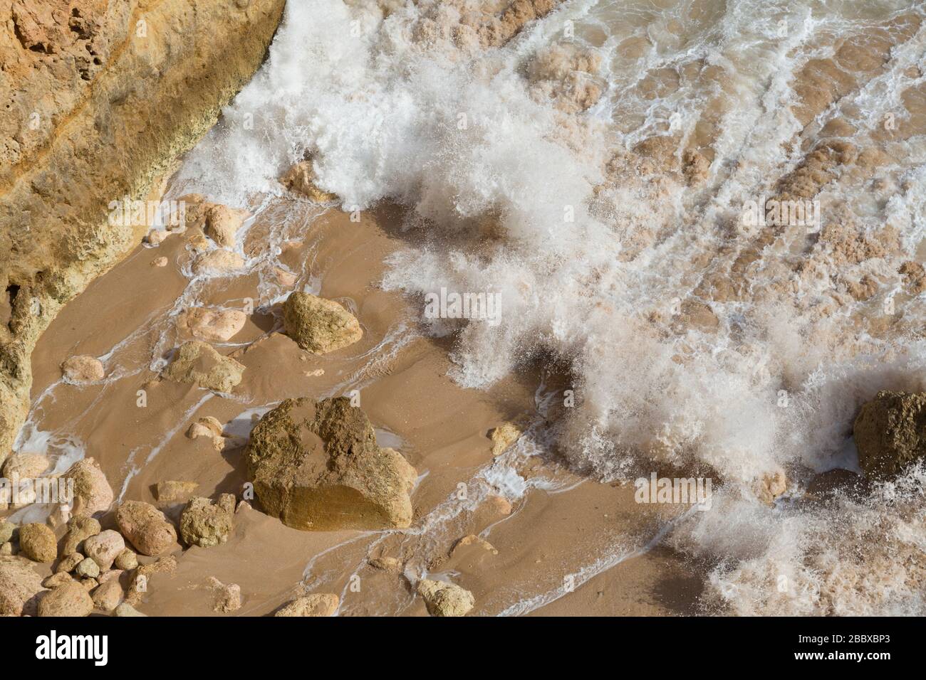 Wave breaking over rocks on the coast west of Alporchinhas, Algarve, Portugal Stock Photo