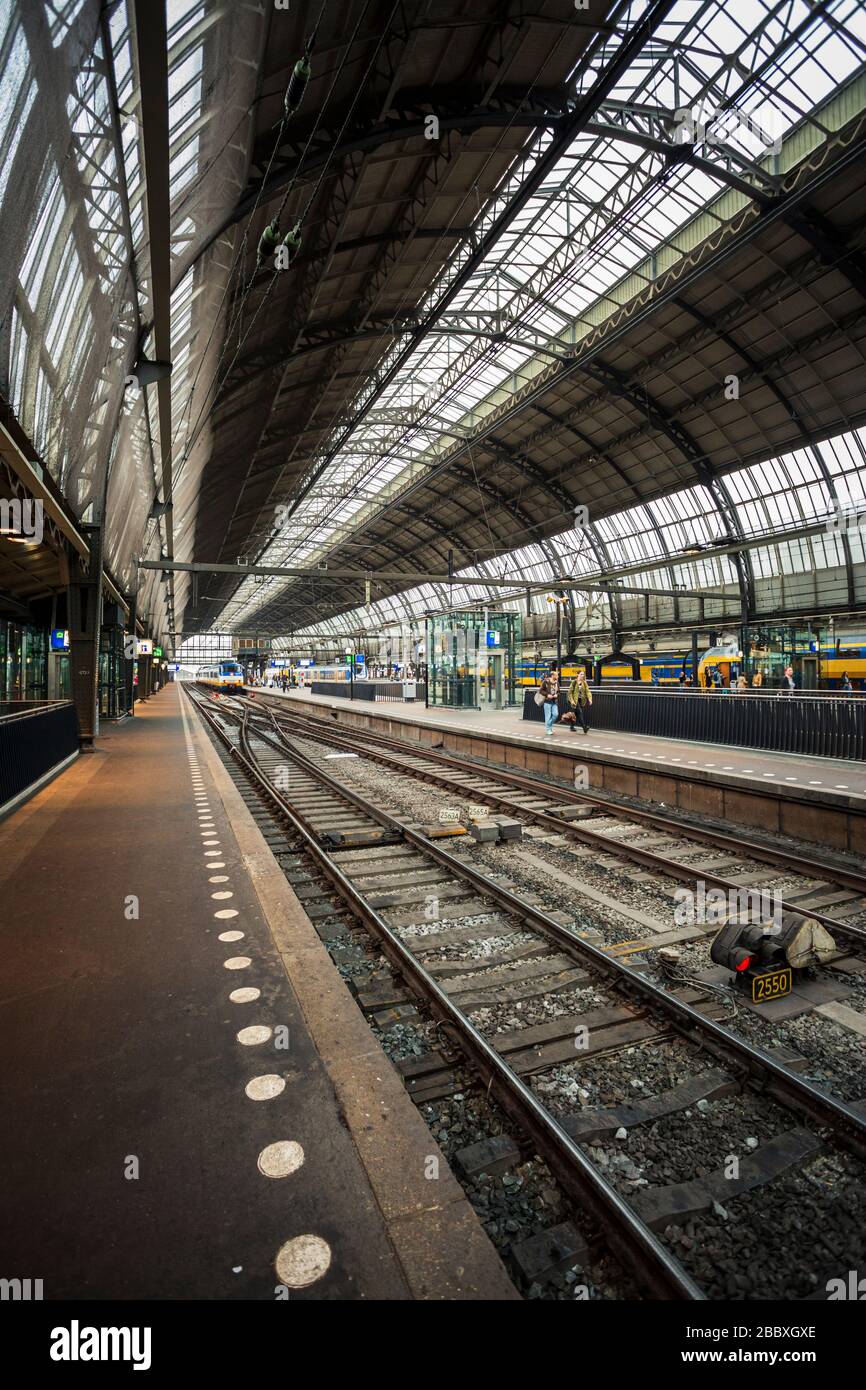 The interior of Amsterdam Centraal train station with an empty train platform. Stock Photo