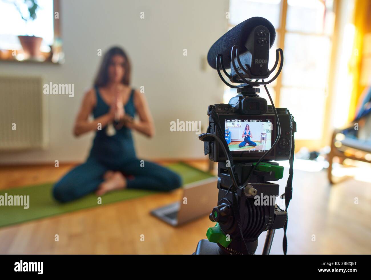 Kaufbeuren, Germany, April 01, 2020. Yoga teacher teaches customers in a online course and live streaming with computer and iphone due to the Corona virus disease (COVID-19) on April 01, 2020 in Kaufbeuren, Germany  Model released © Peter Schatz / Alamy Live News Stock Photo