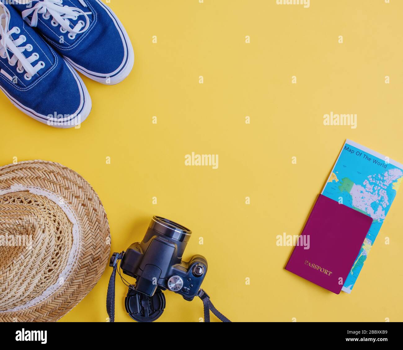 Mockup / mock up of Straw Hat, blue sneakers, black camera, red passport and  map of the world  into passport on yellow summer background, View  from Stock Photo
