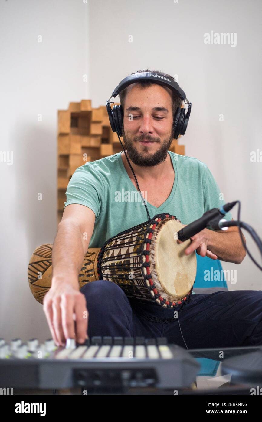 Professional musician recording djembe drum instrument in digital