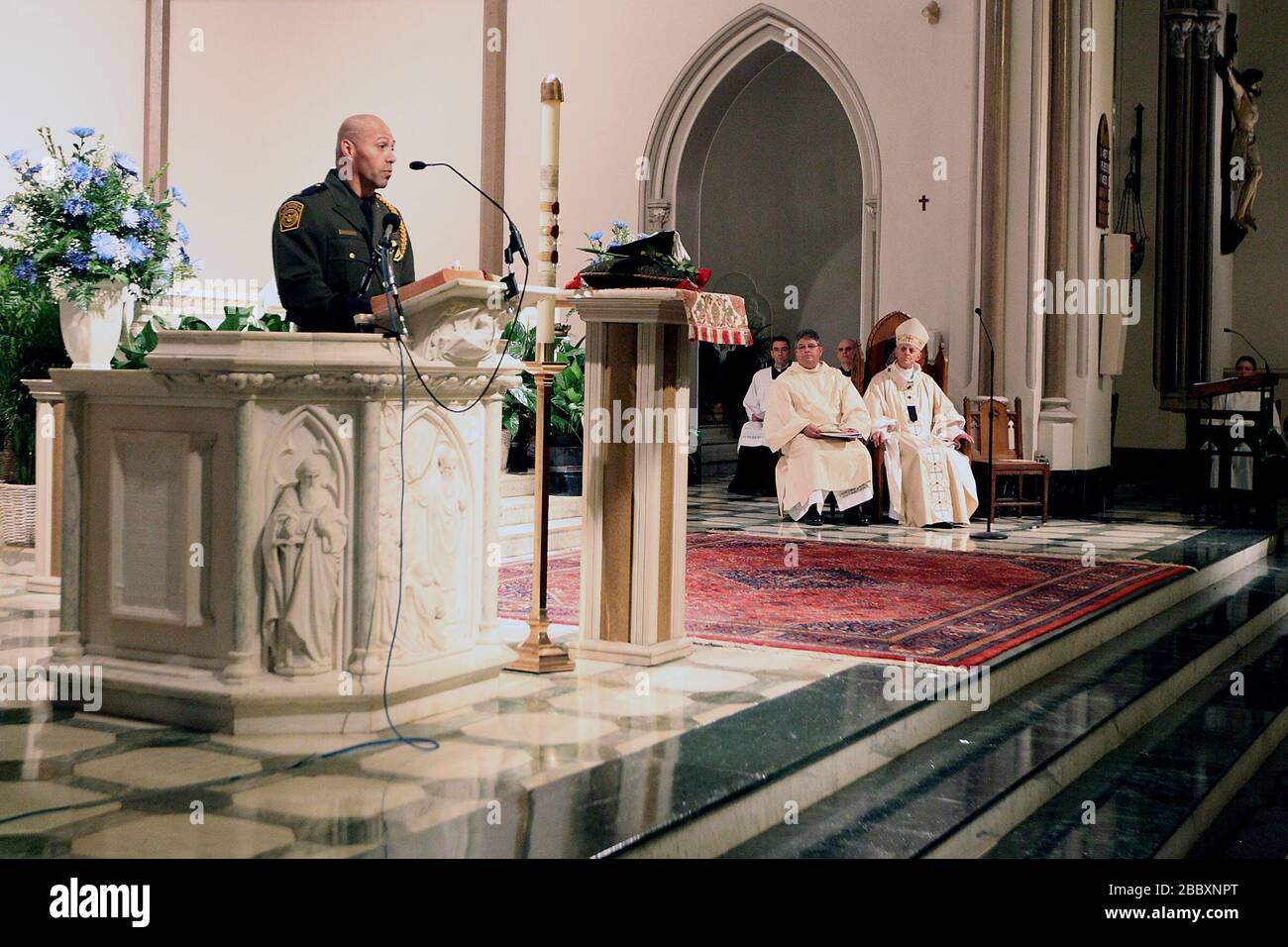 Police Week Blue Mass on May 7, 2013.  Border Patrol Agent reads opening scripture. Stock Photo