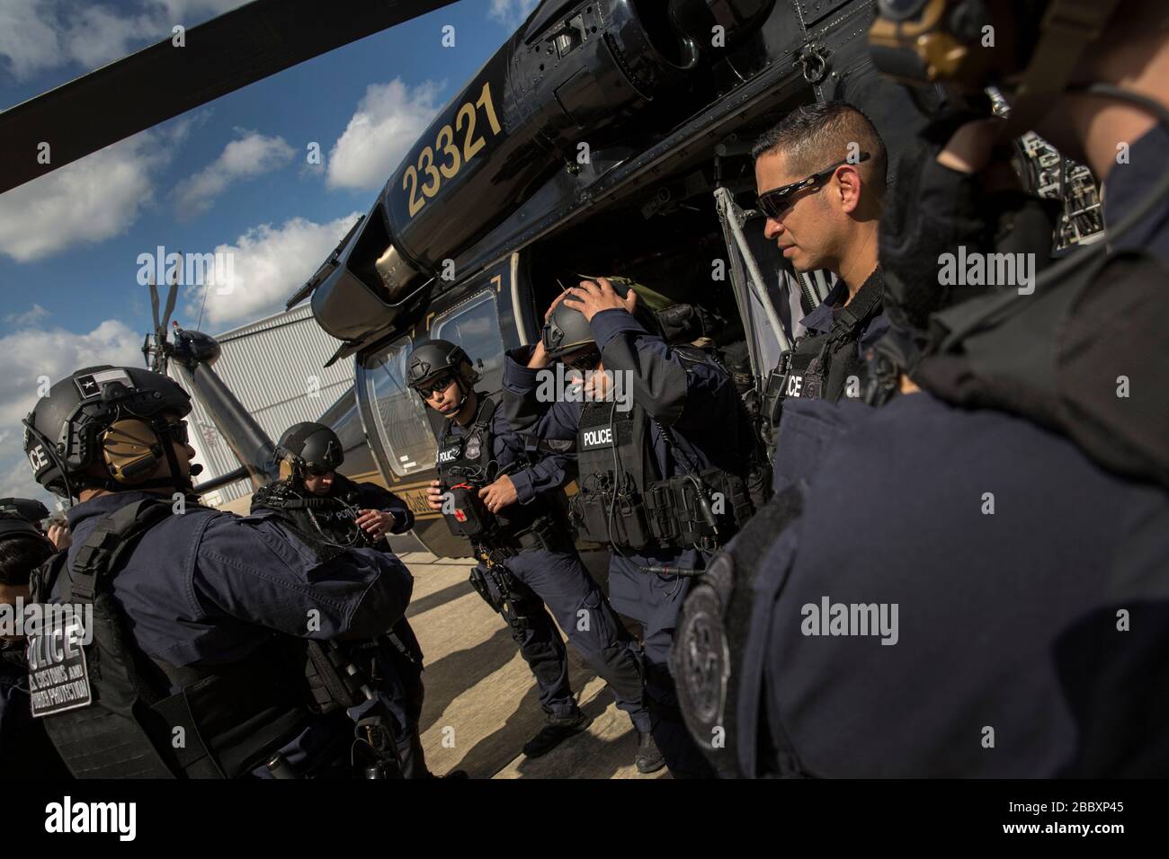 Members of the U.S. Customs and Border Protection, Office of Field Operations Special Response Team, gather outside an AMO UH-60 Black Hawk helicopter after an air-intercept training exercise as they provide airspace security for Super Bowl LI, in Conroe, Texas, Feb. 1, 2017. Units with Air and Marine Operations and Office of Field Operations teamed up with the Civil Air Patrol  to practice an air-to-air intercept using two AMO UH-60 Black Hawk helicopters and two C-550 Citation jets to track down a simulated incursion into restricted airspace. Stock Photo