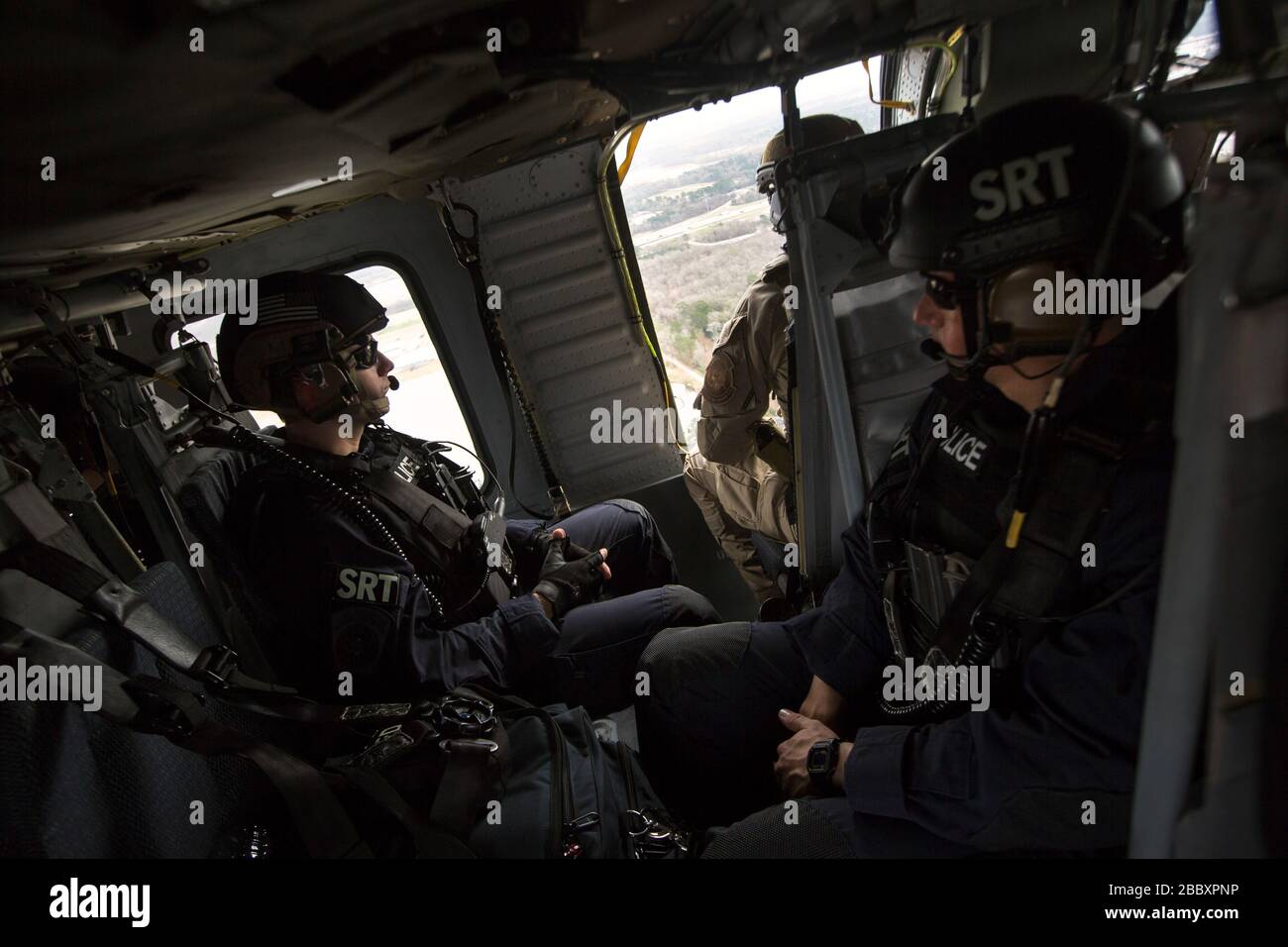 Members of the U.S. Customs and Border Protection, Office of Field Operations Special Response Team, remain prepared during a flight on an AMO UH-60 Black Hawk helicopter air-intercept training exercise as they provide airspace security for Super Bowl LI, in Conroe, Texas, Feb. 1, 2017. Units with Air and Marine Operations and Office of Field Operations teamed up with the Civil Air Patrol  to practice an air-to-air intercept using two AMO UH-60 Black Hawk helicopters and two C-550 Citation jets to track down a simulated incursion into restricted airspace. Stock Photo