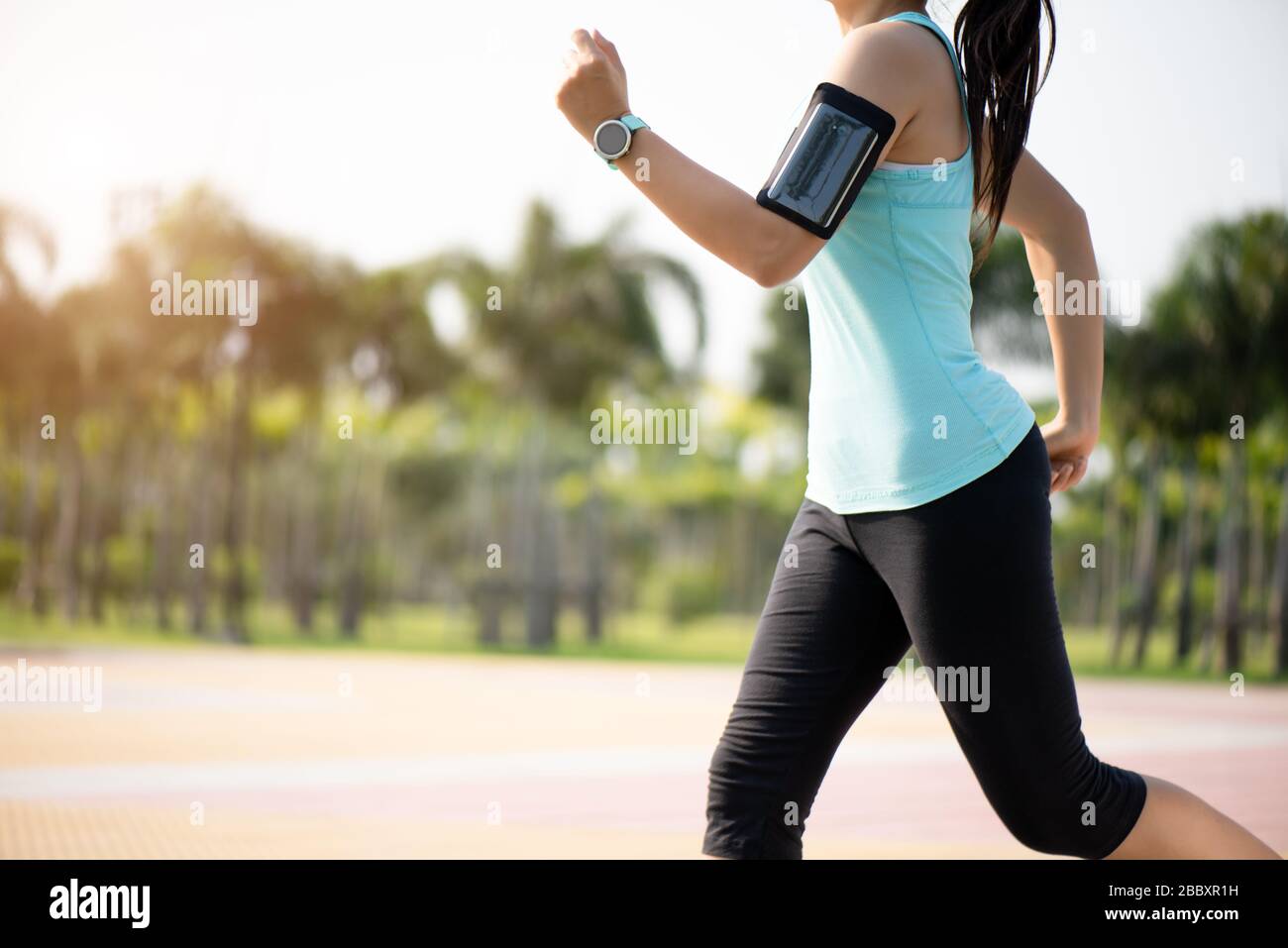 Closeup woman running towards on the road side. Step, run and outdoor exercise activities concept. Stock Photo