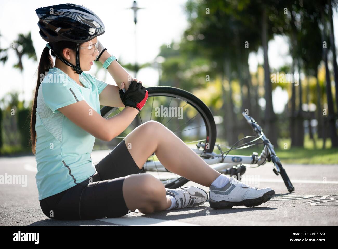 Bike injuries. Young woman cyclist fell fell off road bike while