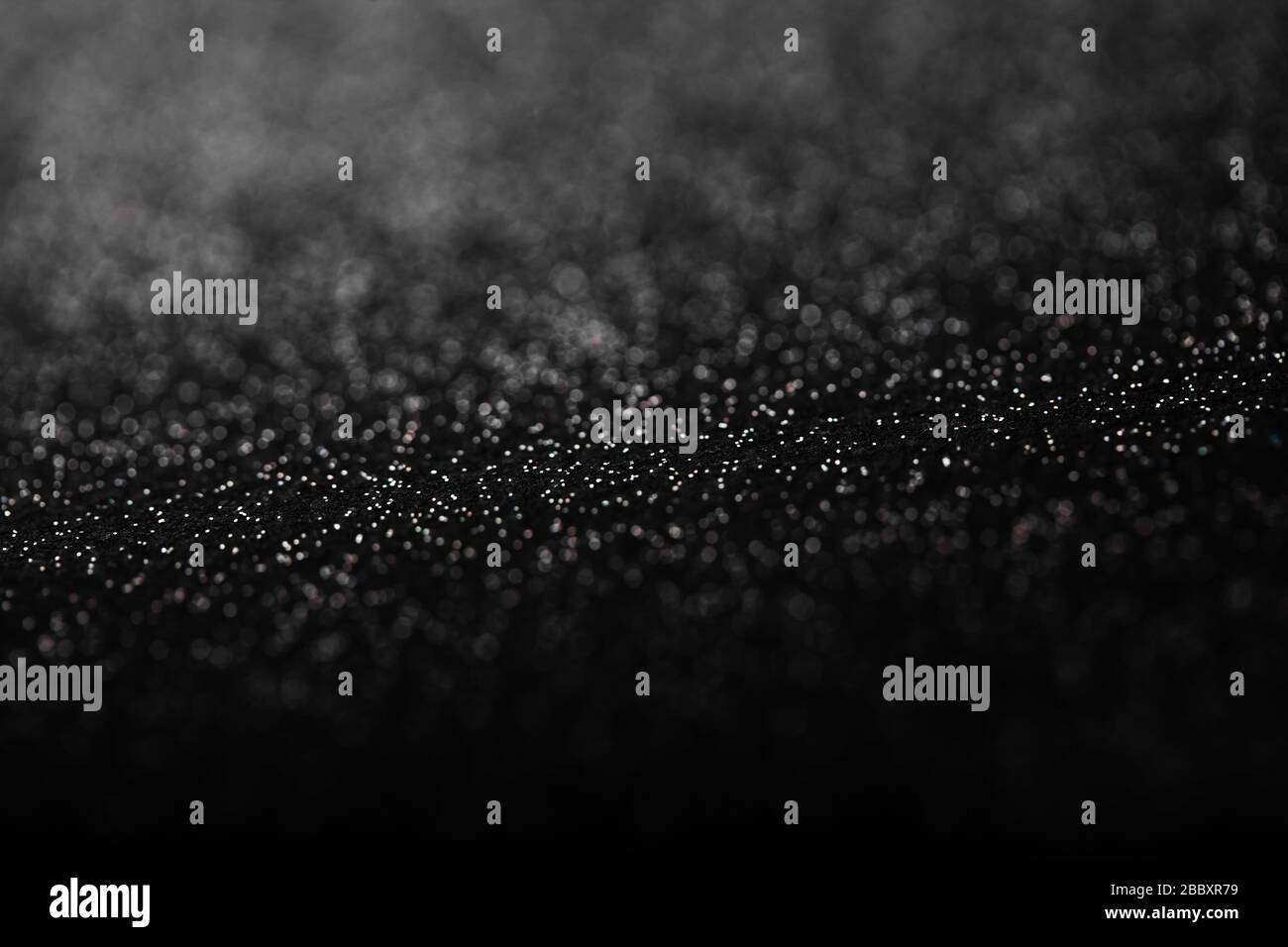 Black and white abstract background with small bokeh defocused lights ...