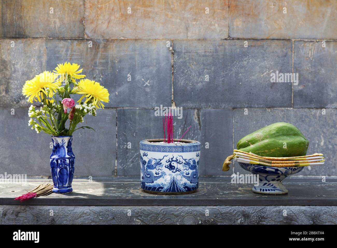 Flower Vase, Buddhist Incense and Fruit Dish Arrangement Detail in a Buddhist Temple, Tu Duc Emperor Tomb, Hue Vietnam Stock Photo