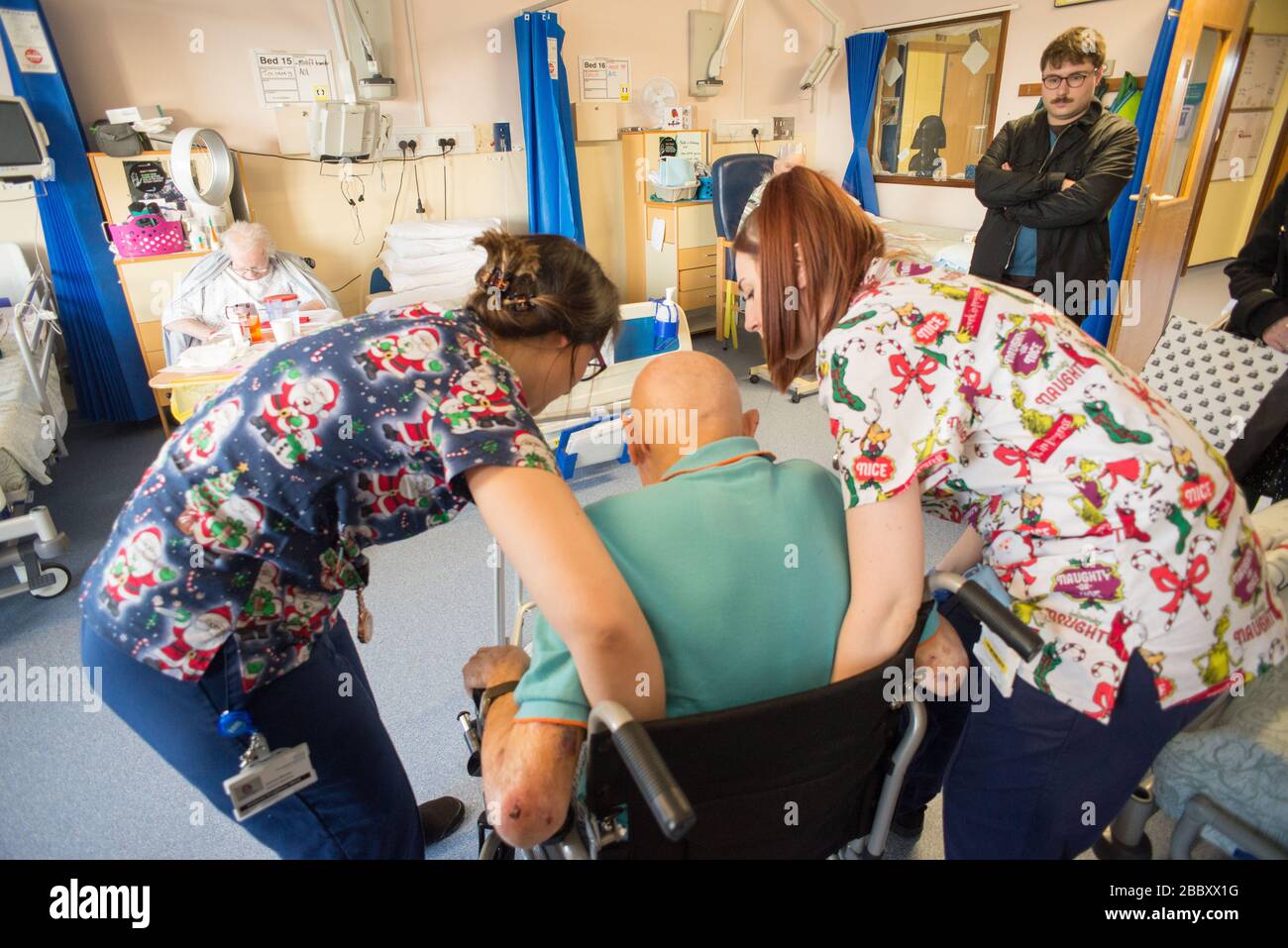 ANDOVER,HAMPSHIRE/UNITED KINGDOM- DECEMBER 25 2019:An elderly man with brain injury is being helped to walk using a walking frame,by nursing staff,sur Stock Photo