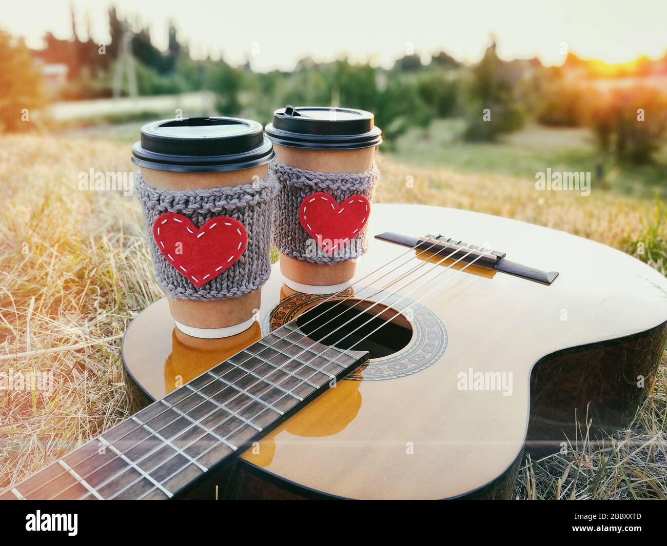 Two paper coffee cup in knitted cozy sleeves standing on guitar ...