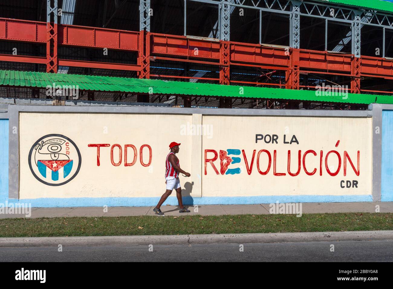 Man Walking Near Propaganda Wall Painting, Puentes Grandes Neighbourhood, Havana Stock Photo