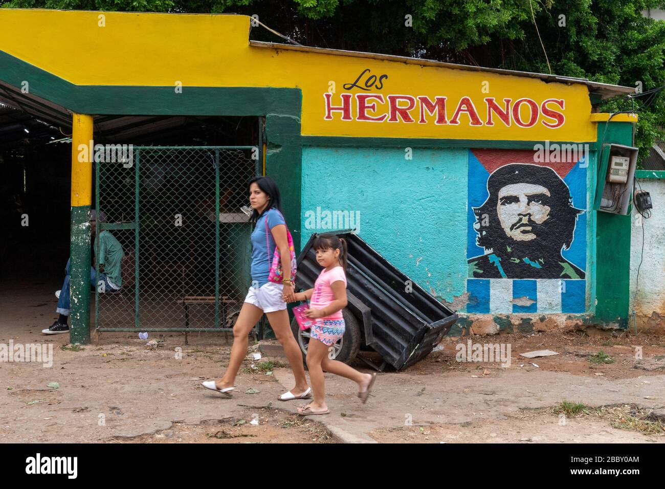 Woman and child walhing near Che Guevara wall painting propaganda Stock Photo