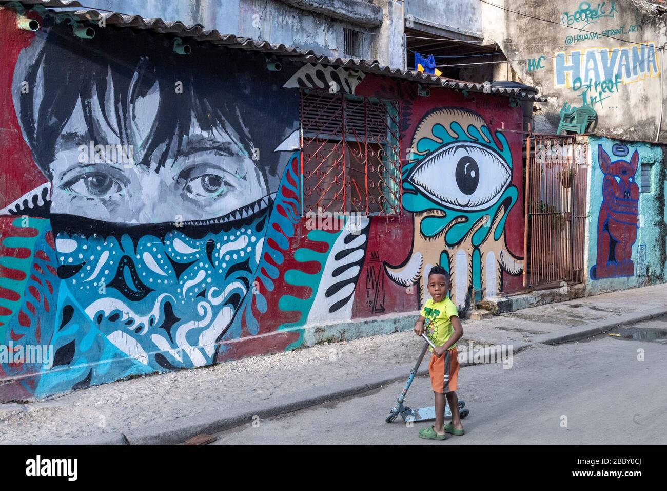 Boy walking by street art mural, Old Havana Stock Photo