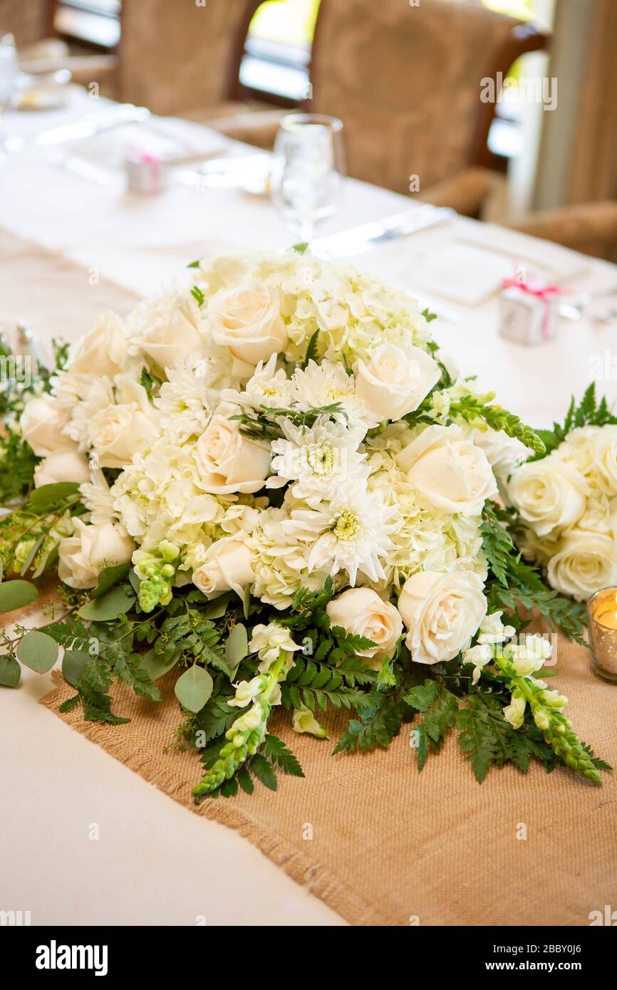 White roses and daisies decorating a table for a wedding party Stock Photo
