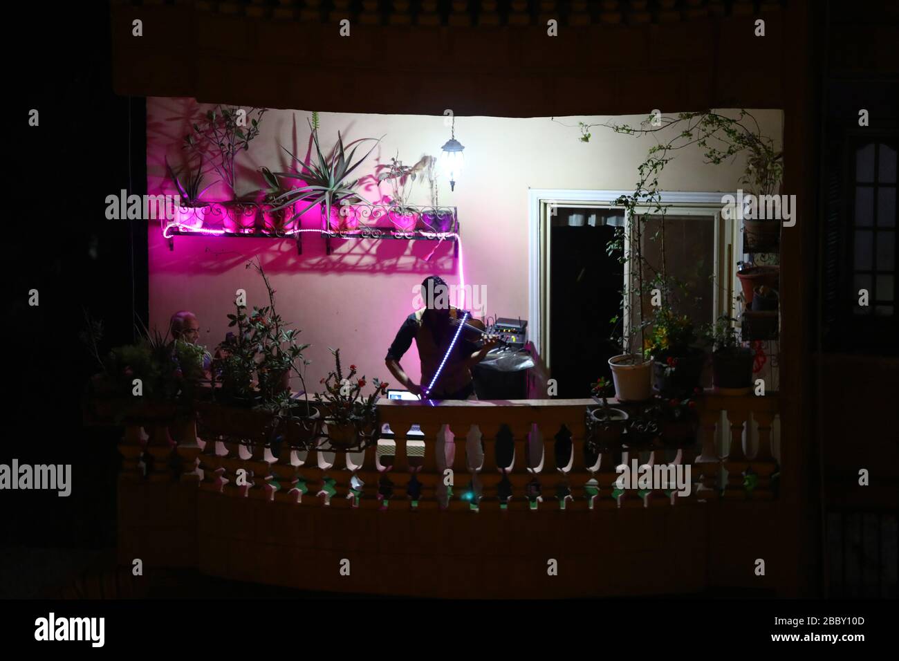 Cairo. 31st Mar, 2020. Egyptian violinist Mohammed Adel plays the violin during his balcony