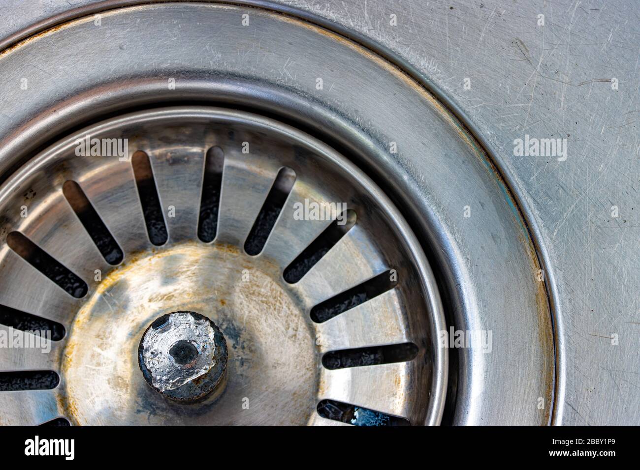 A metal sink with drain hole, macro view. Mechanically adjustable drain plug closeup. Stock Photo