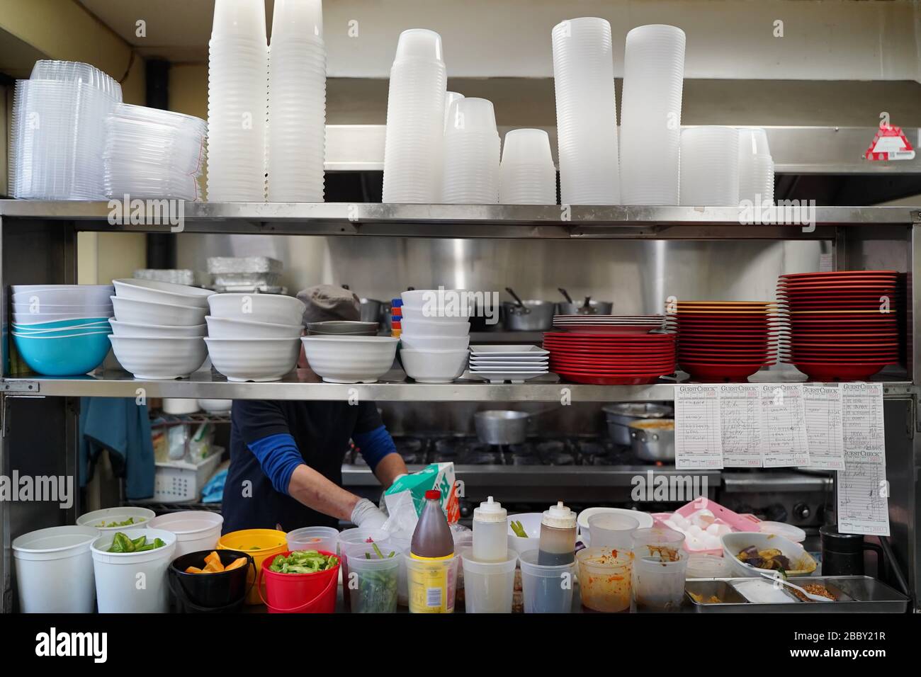 https://c8.alamy.com/comp/2BBY21R/new-york-ny-usa-february-28-2020-new-york-ny-usa-february-28-2020-a-cook-works-tirelessly-behind-the-stacks-of-bowls-and-containers-2BBY21R.jpg