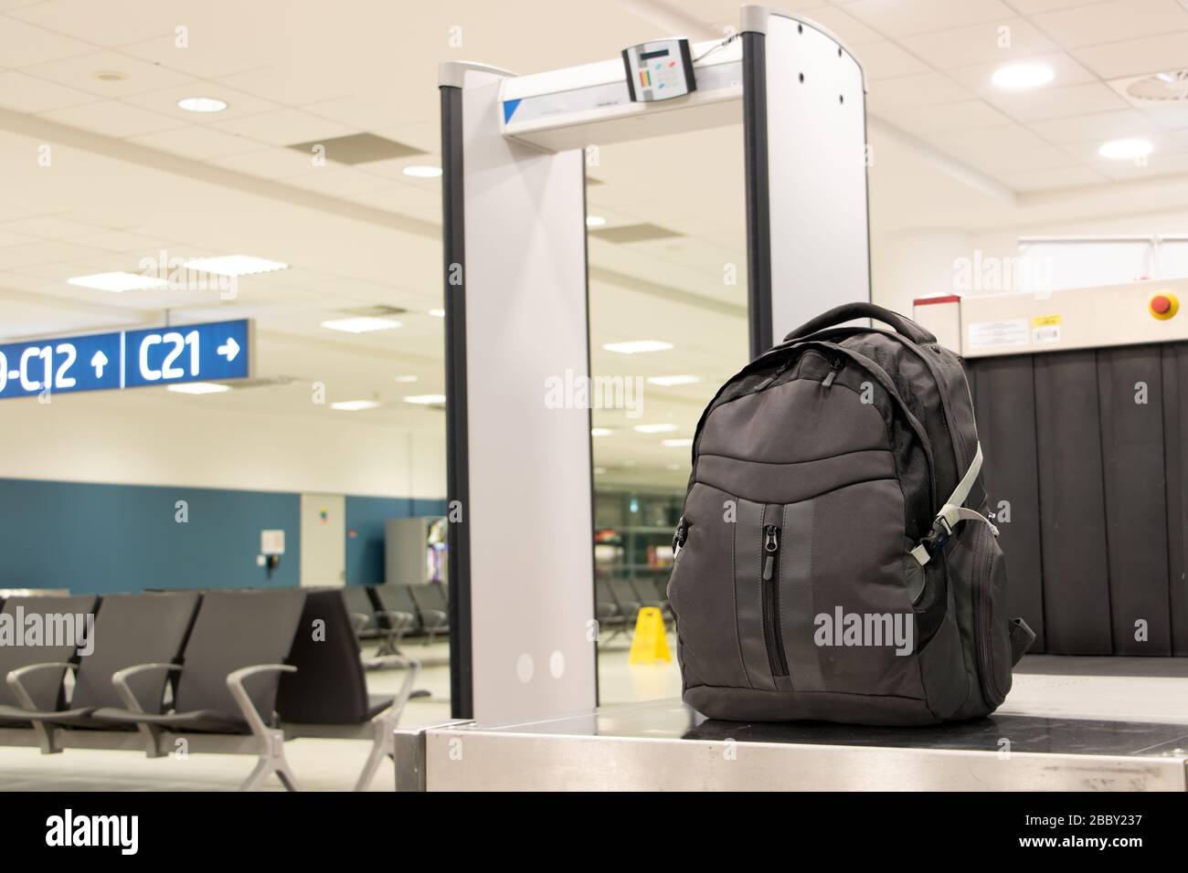 Backpack standing in front of luggage scanner at airport terminal. Baggage at checkpoint at departure gate. Stock Photo