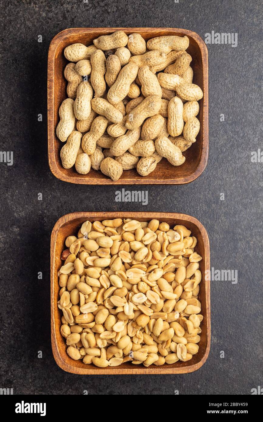 Roasted salted peanuts. Crispy nuts. Peeled and unpeeled peanuts in bowl. Top view. Stock Photo