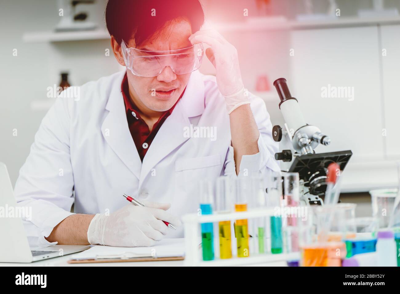 Scientist hardworking headache illness during longtime working in medical lab test Stock Photo