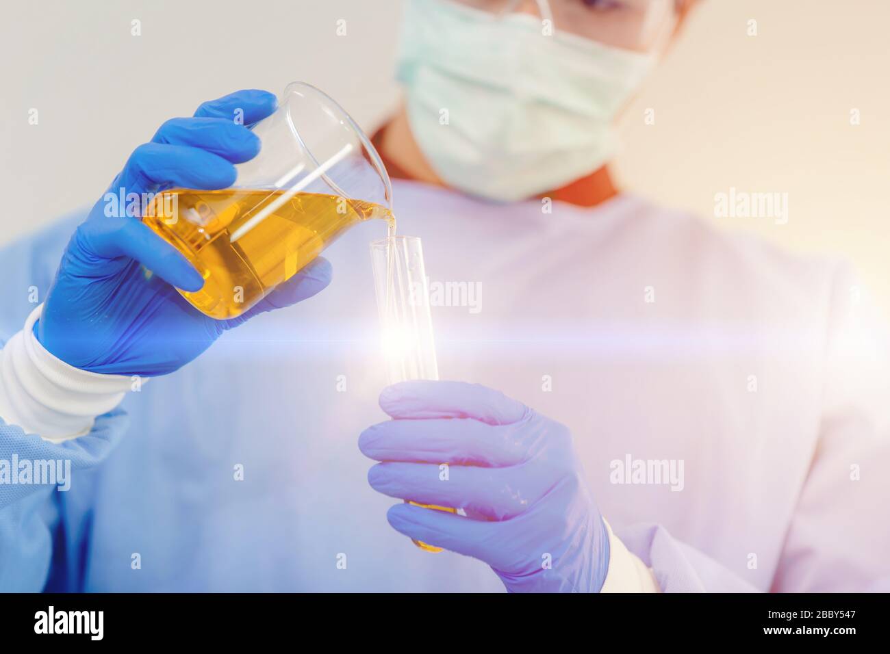 Scientist dressing blue disposable scrub suits for safety and protection during working with danger virus in medical lab Stock Photo
