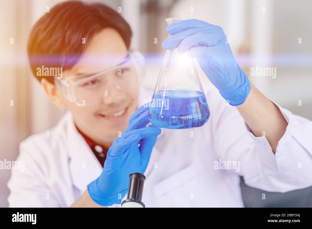 Scientist happy to successful discover new anti virus drug formula chemical liquid in hospital medical science lab Stock Photo