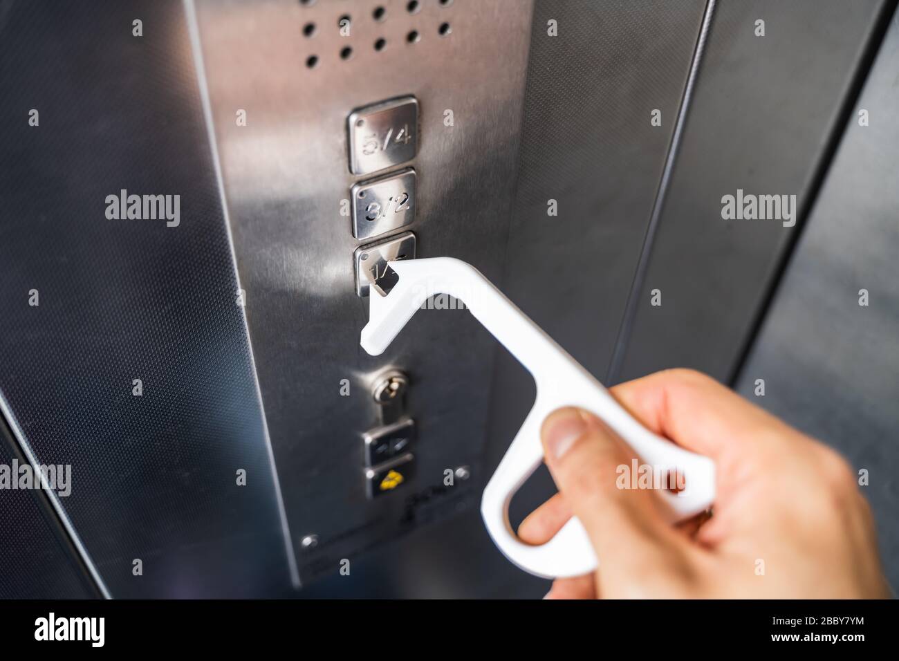 Man Using Contactless Tool To Press Button To Protect From Coronavirus Infection Stock Photo