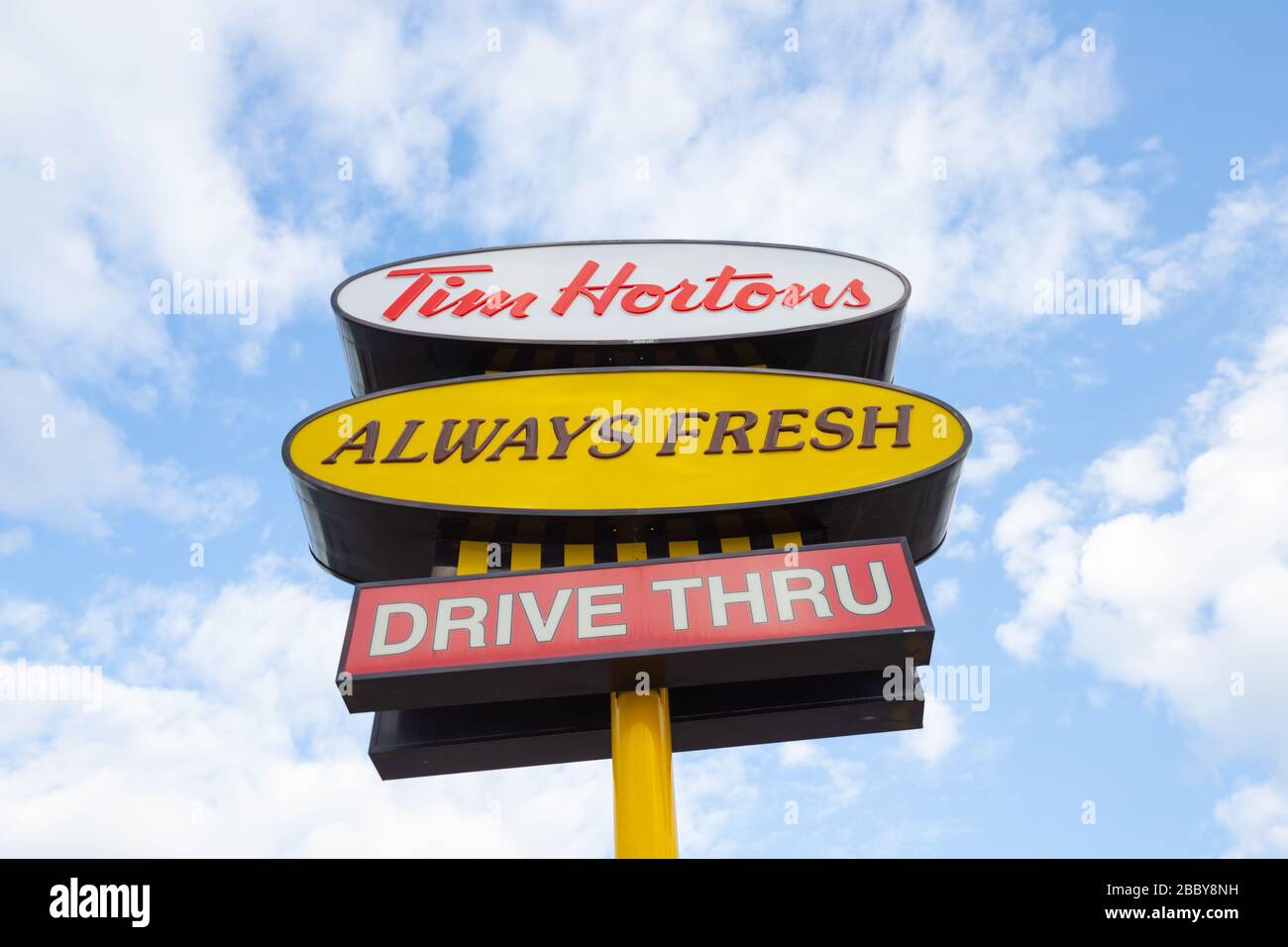 Billboard Sign showing Tim Hortons fast food restaurant logo and slogan with sky background Stock Photo
