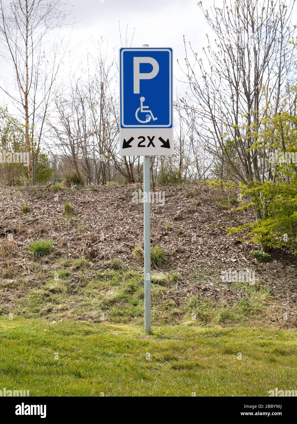 Disabled parking bay sign standing on the grass Stock Photo