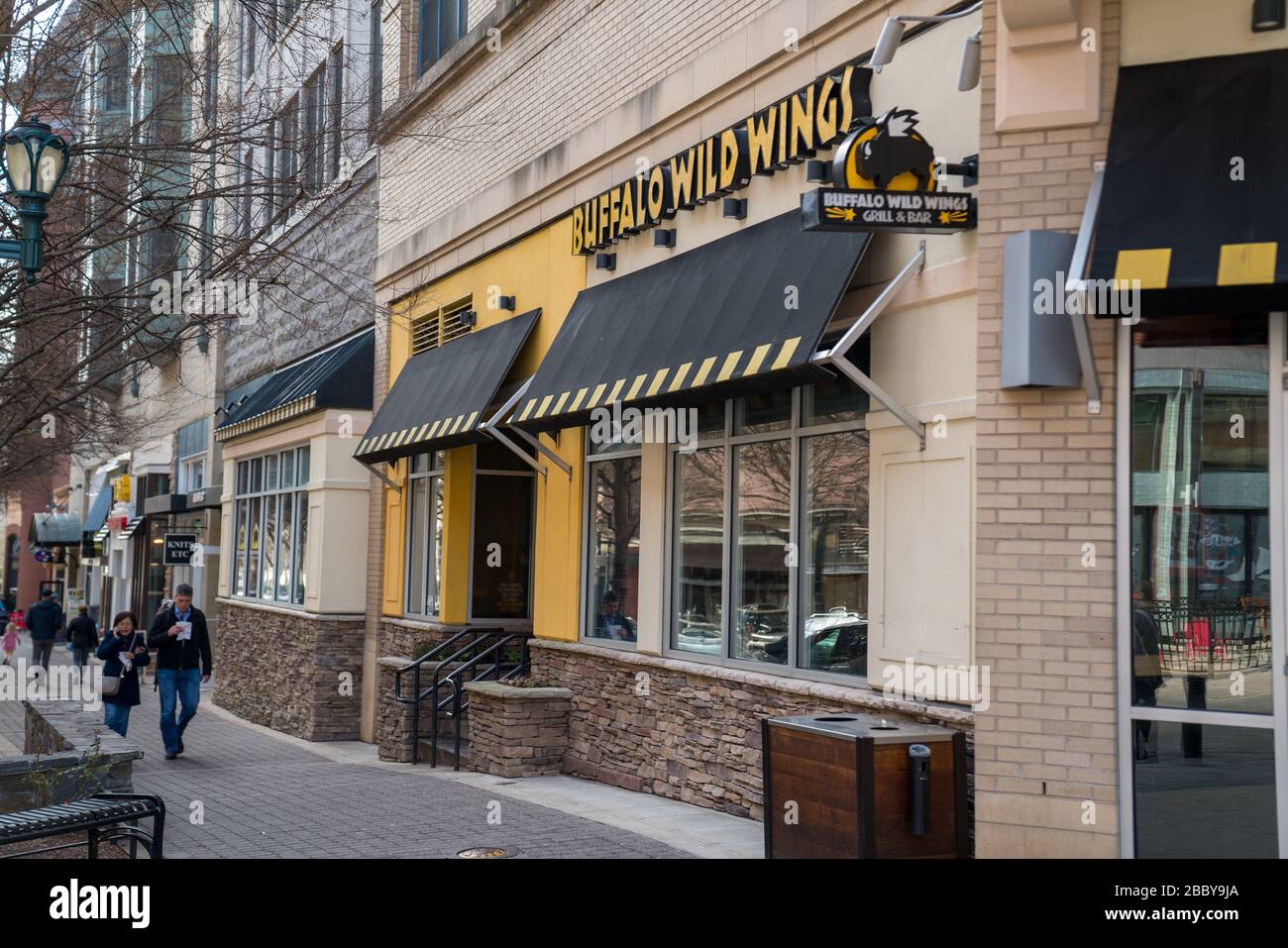 Buffalo Wild Wings restaurant location on street with people walking by
