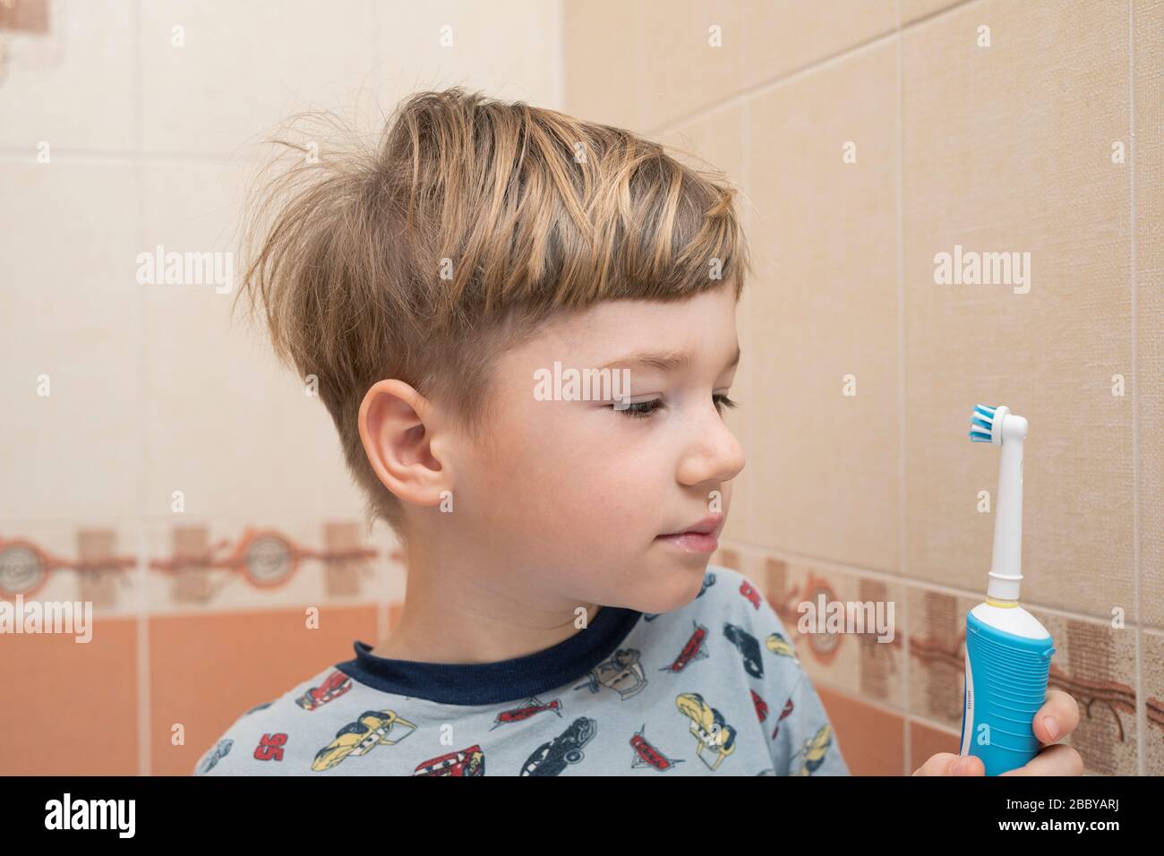 boy preschooler in pajamas brushes his teeth before going to bed. Stock Photo